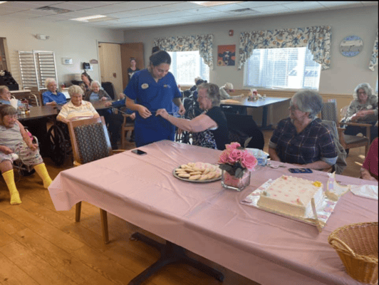 Residents celebrating with cake and cookies in the activity room