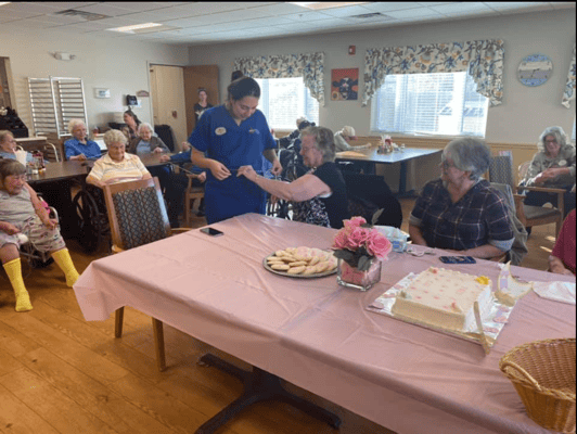 Residents celebrating with cake and cookies in the activity room