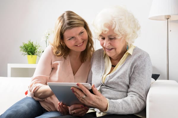 A caregiver and a resident enjoying time together with a tablet