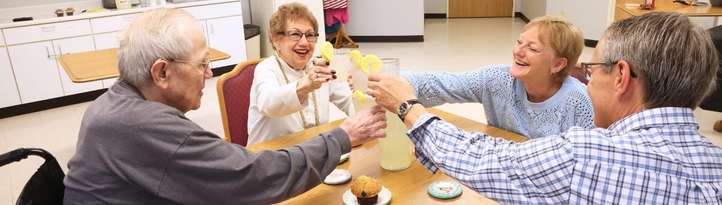 Residents toasting drinks in a dining area