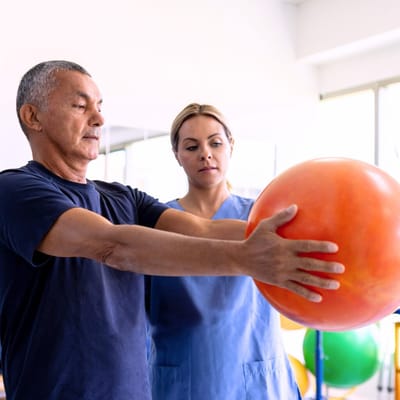 A senior resident exercising with a staff member