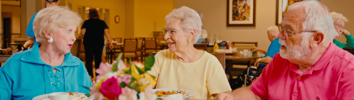 Three residents enjoying a meal in the dining room