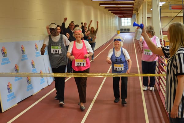 Seniors participating in a fun running event indoors