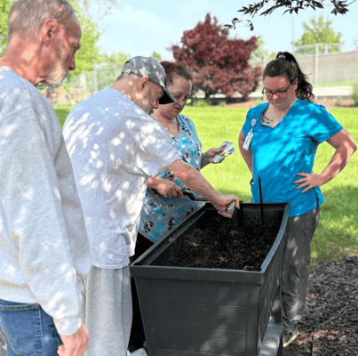 Residents and staff gardening in an outdoor space