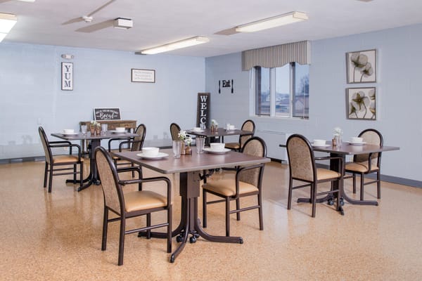 Brightly lit dining room with tables set for meals
