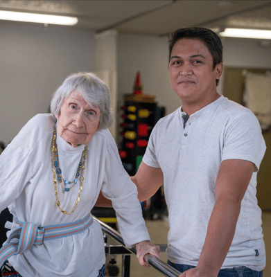 A senior resident with a staff member in a facility