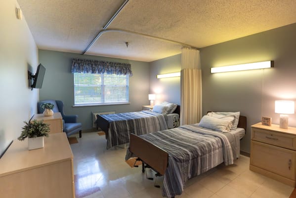 Brightly lit shared resident room with two beds