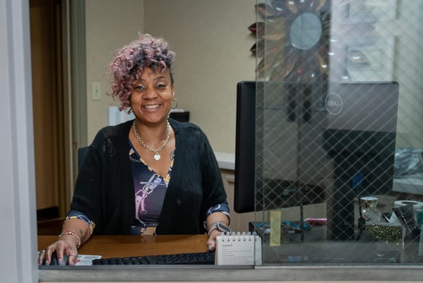 Receptionist smiling at the front desk of a senior facility
