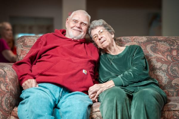 Happy elderly couple sitting on a couch together