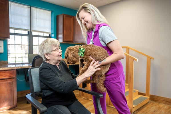 A caregiver assisting a resident with a dog