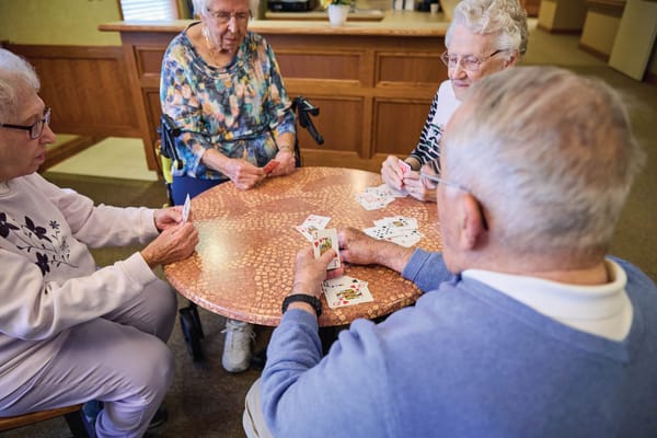 Residents playing cards at a common table