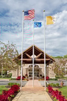 Front entrance of a senior living facility with flags