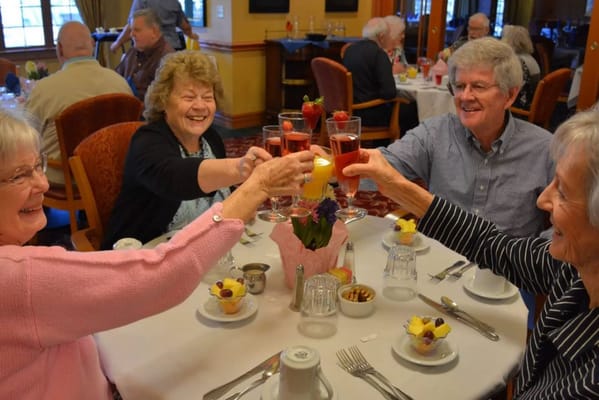 Residents celebrating with drinks at a dining table