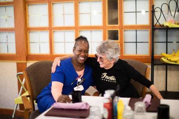 Staff member and resident enjoying a cheerful moment together