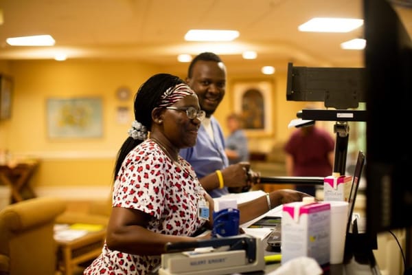 Staff members smiling at a reception desk in the facility