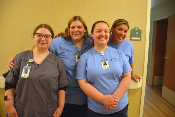 Staff members smiling in a hallway