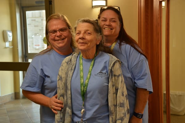 Staff and resident smiling together indoors