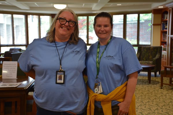 Two staff members smiling in a common area