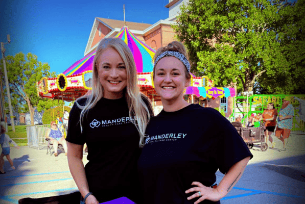 Two staff members smiling at a community event