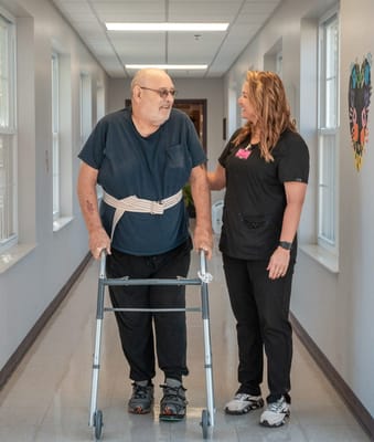 Staff assisting a resident in a hallway
