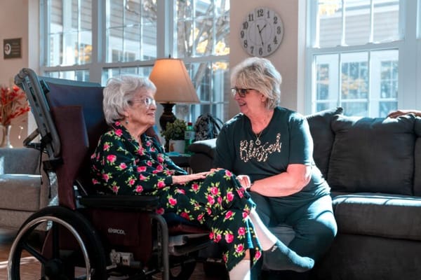 A resident and staff member in a cozy living area