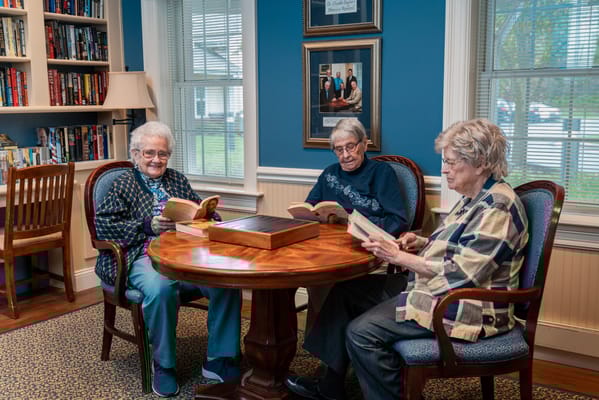 Residents reading together in a cozy library setting