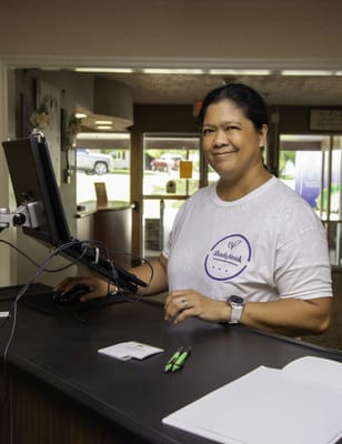 Staff member at the reception desk smiling