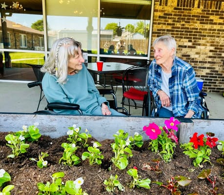 Two residents chatting in a garden area