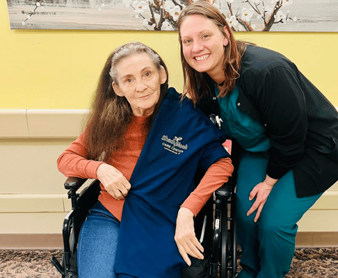 A resident and staff member smiling together