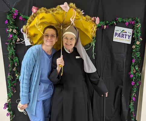 Staff and resident celebrating Mardi Gras with props