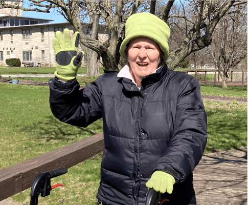 Senior resident waving in outdoor space
