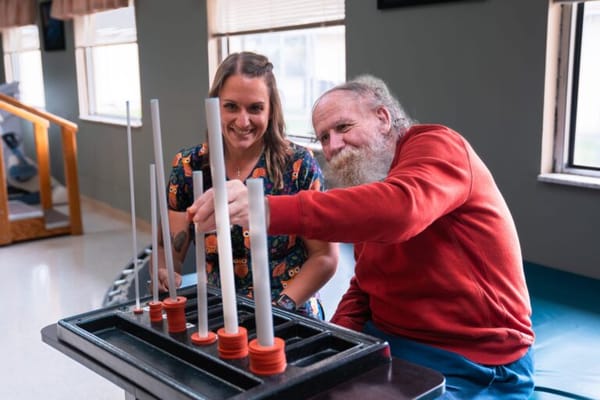A resident and staff member engaging in a therapeutic activity