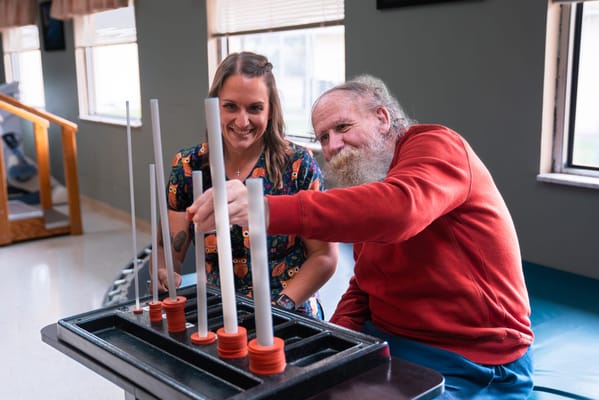 A resident and staff member engaging in a therapeutic activity