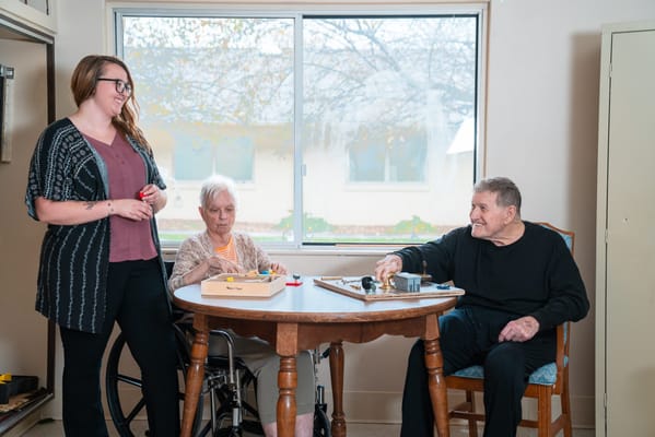 Residents engaging in a game with staff assistance