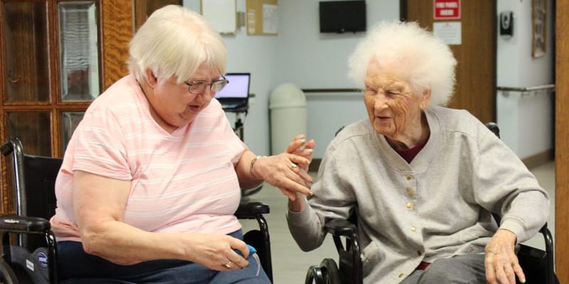Two residents engaged in conversation in a common area
