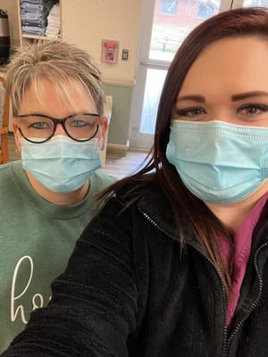 Two staff members wearing masks in an interior setting