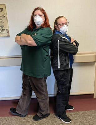 Two staff members posing in a hallway