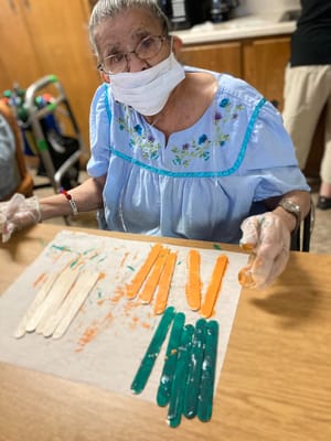 Senior resident engaging in a craft activity with colorful materials