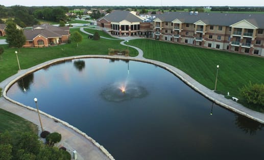 Aerial view of a serene pond surrounded by landscaped grounds