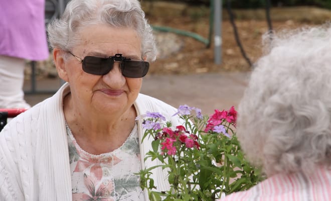 Two residents enjoying flowers outdoors