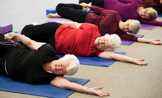 Residents participating in a yoga class on mats
