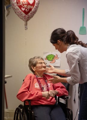 A staff member interacting with a resident in a cheerful setting