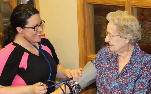 Staff member measuring a resident's blood pressure