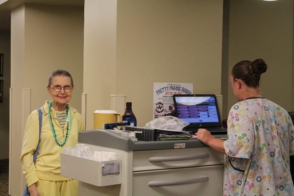 Resident and staff member interacting in a hallway