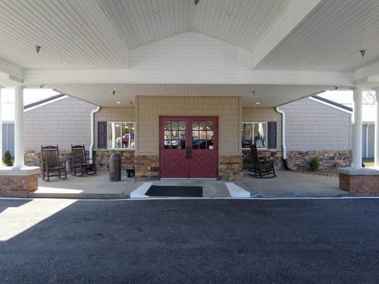 Entrance of a senior living facility with rocking chairs