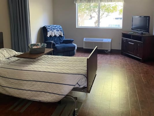 A private resident room with a bed and seating area