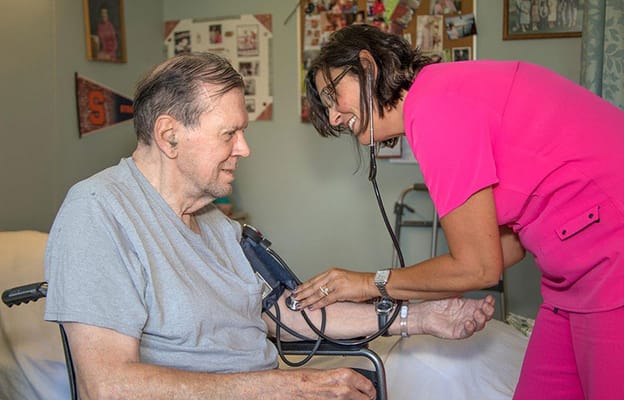 Nurse taking a patient's blood pressure in a cozy room
