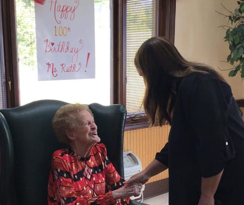 Resident celebrating her 100th birthday with staff