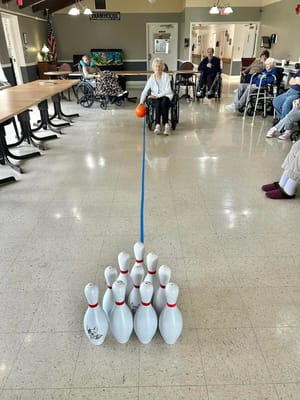 Residents participating in a bowling activity indoors
