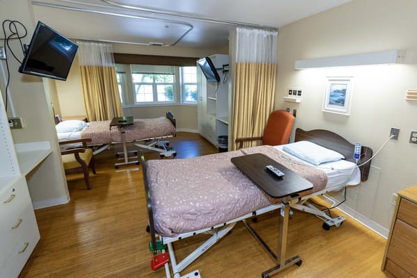 A spacious resident room with two hospital beds